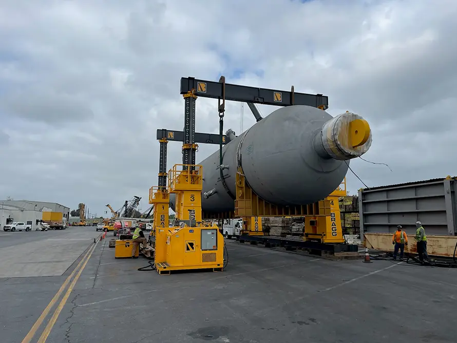A crane lifting a large object against a clear sky, showcasing the power of heavy machinery in construction.