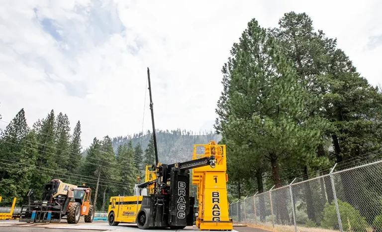 A large yellow machine is parked on the side of a road, showcasing its size and vibrant color against the surroundings.