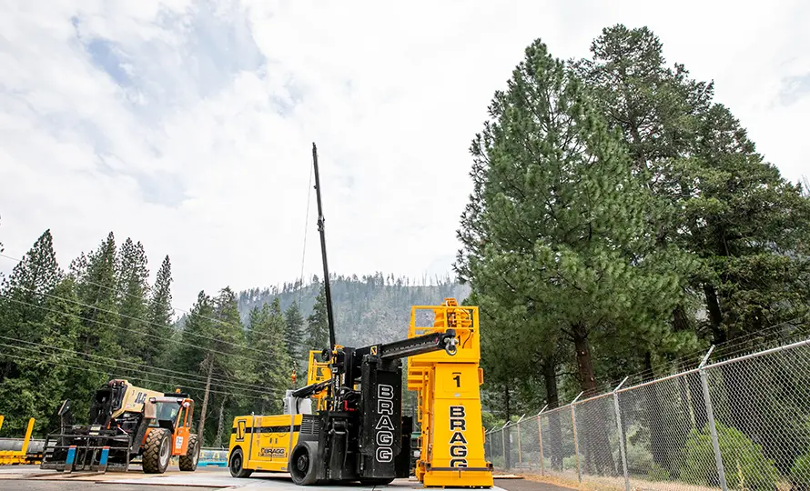 A large yellow machine is parked on the side of a road, showcasing its size and vibrant color against the surroundings.